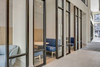 A long corridor with tables and chairs in a hotel lobby
